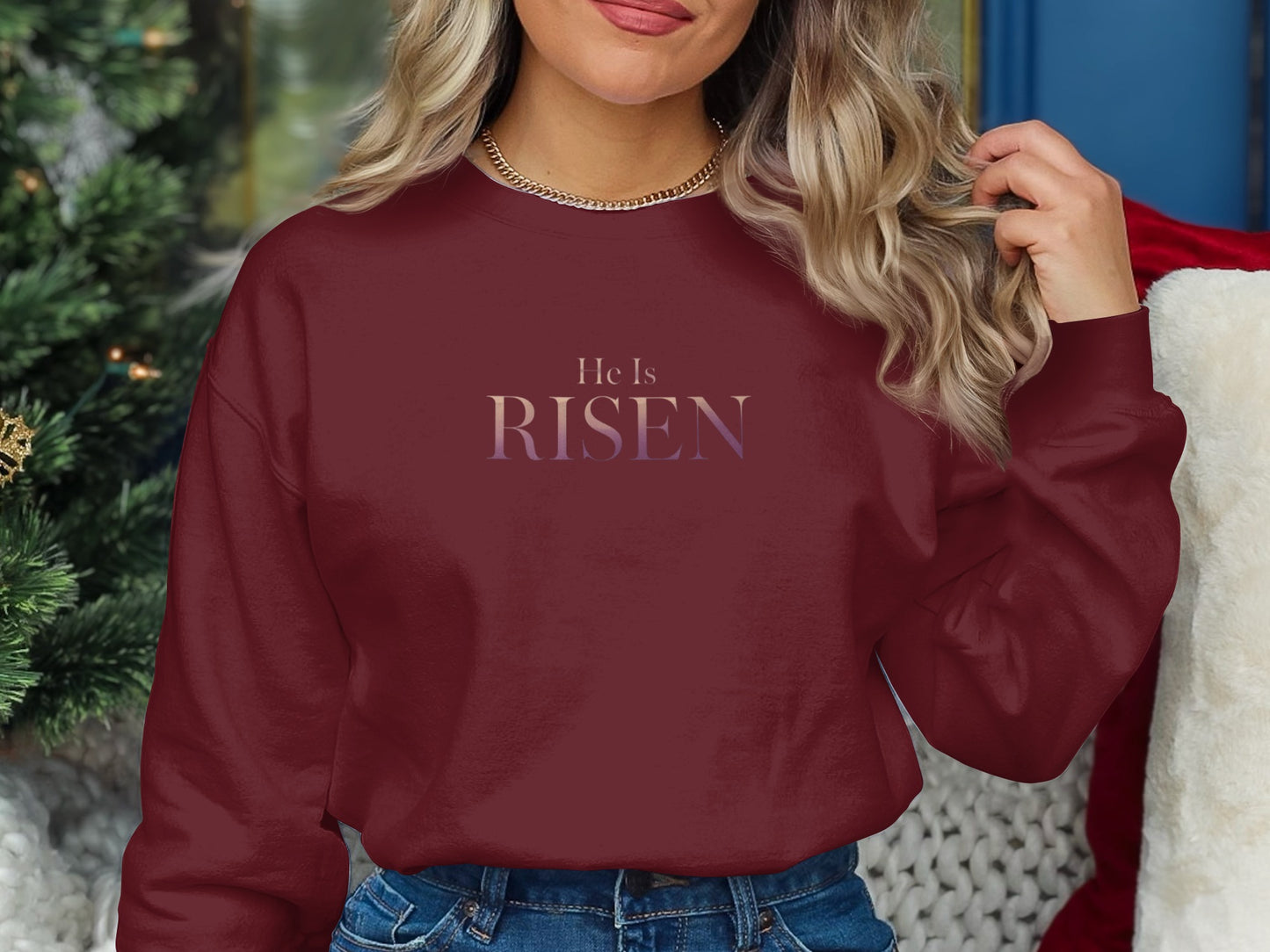 Maroon crewneck sweatshirt with "He Is Risen" text in gradient purple and pink.