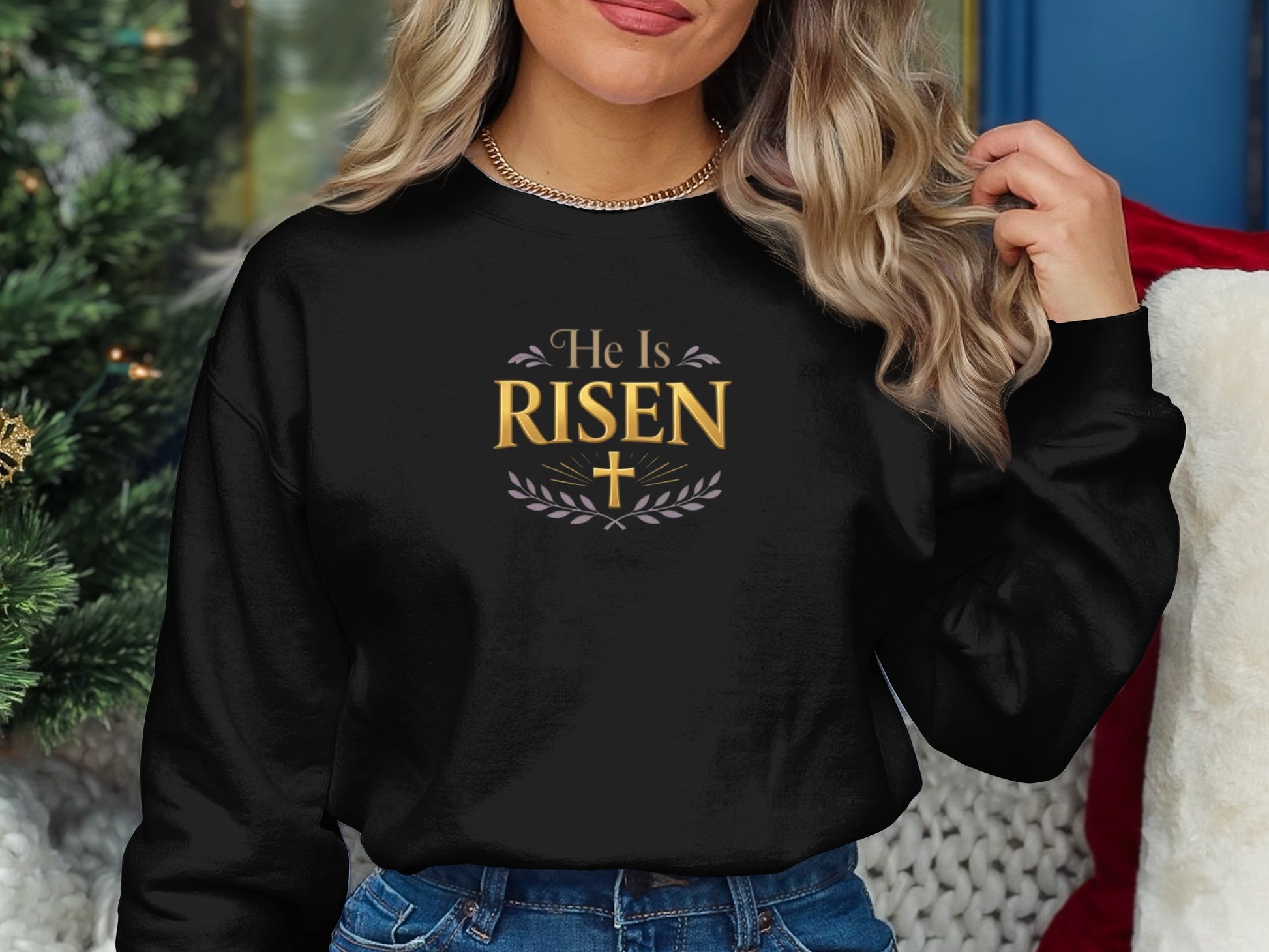 Black sweatshirt with "He Is Risen" text and laurel wreath graphic.