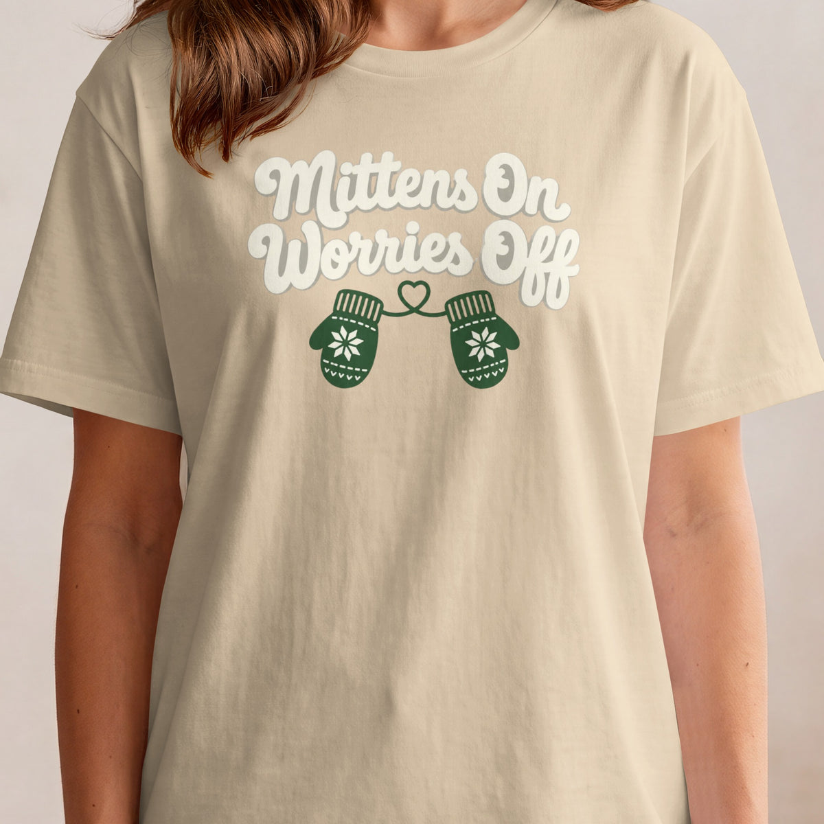 Cream t-shirt with "Mittens On Worries Off" text and green mittens graphic.