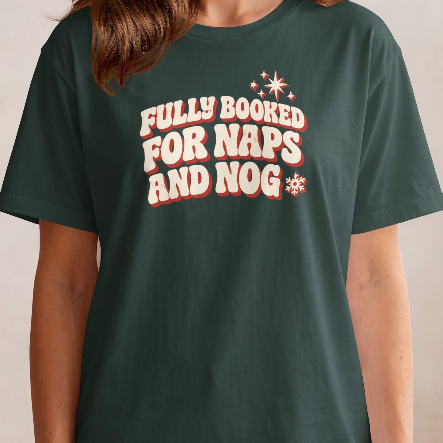 Dark green t-shirt with "FULLY BOOKED FOR NAPS AND NOG" text and holiday graphics.