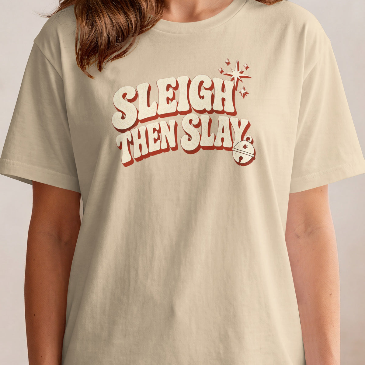 Light cream t-shirt with red and cream text "Sleigh Then Slay" and holiday graphics.