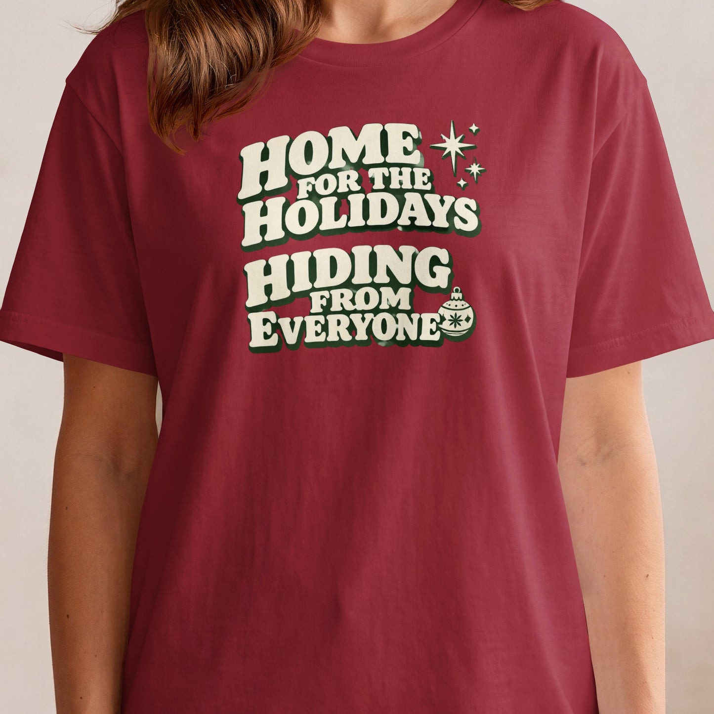 Maroon t-shirt with "Home for the Holidays Hiding From Everyone" text and holiday graphic.