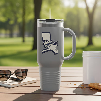 Gray tumbler with California outline and text logo, resting on a wooden table.