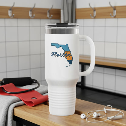 Travel tumbler with Florida Sunshine State logo, outdoors.