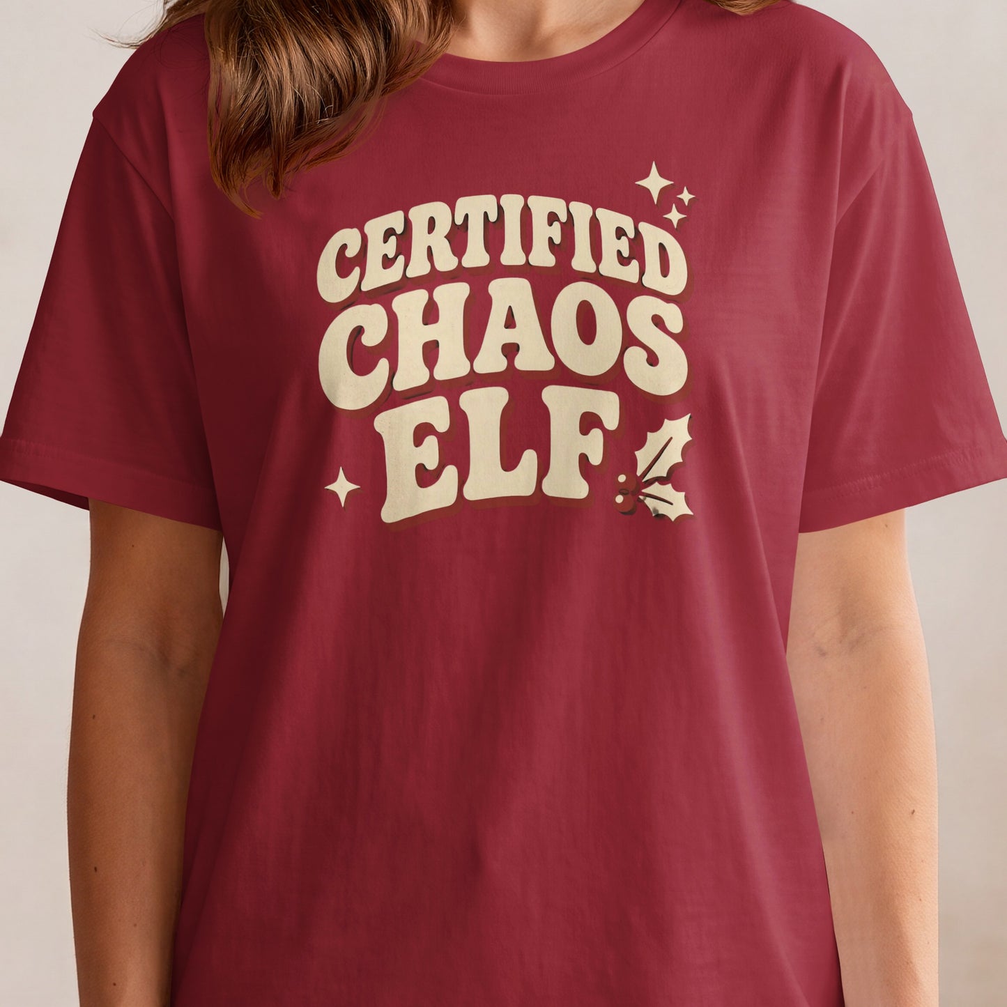 Maroon t-shirt with "Certified Chaos Elf" text and festive embellishments.