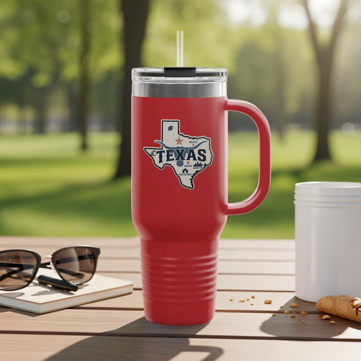 Red tumbler with Texas state logo and handle, resting on a wooden table.
