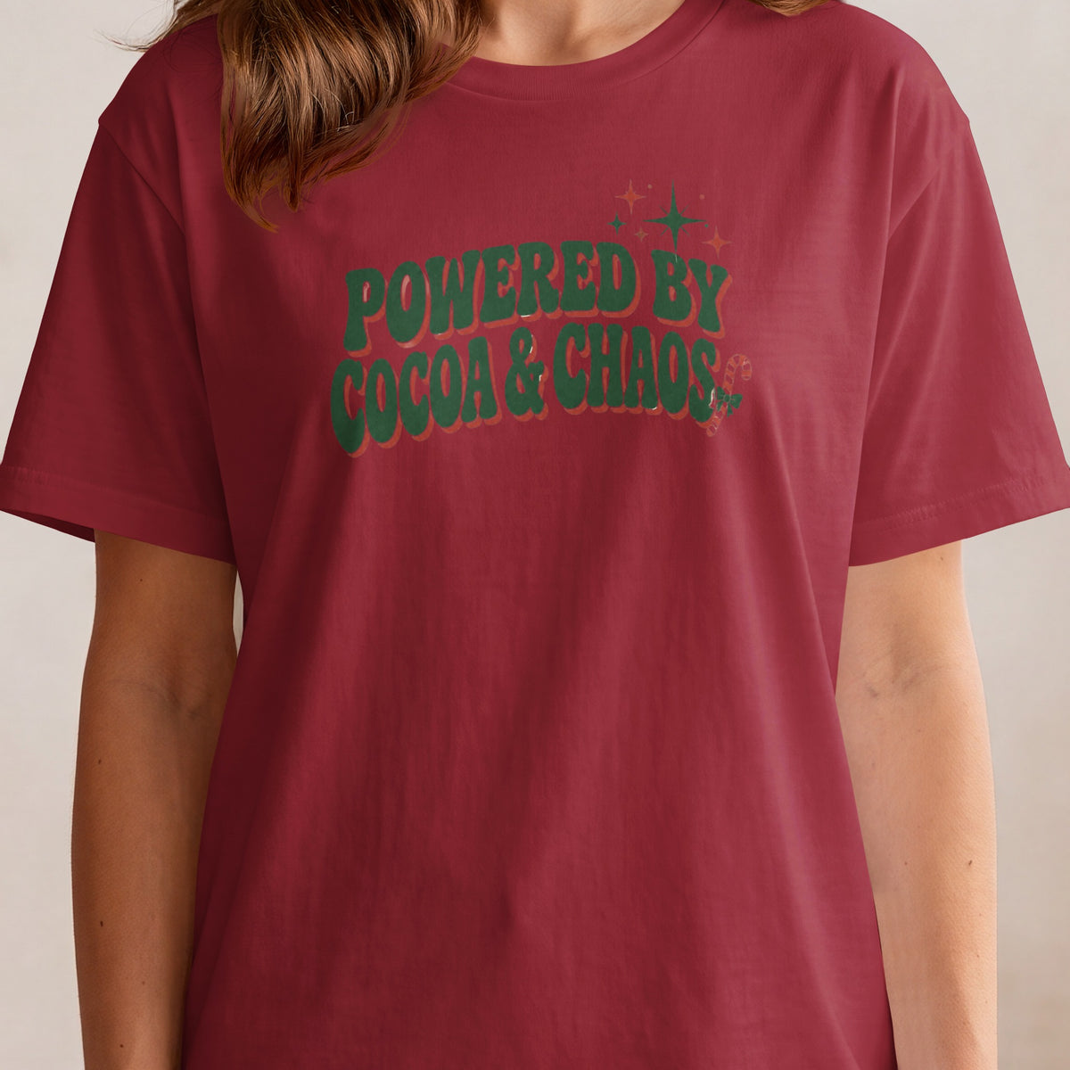 Red t-shirt with "POWERED BY COCOA & CHAOS" text and holiday graphics.