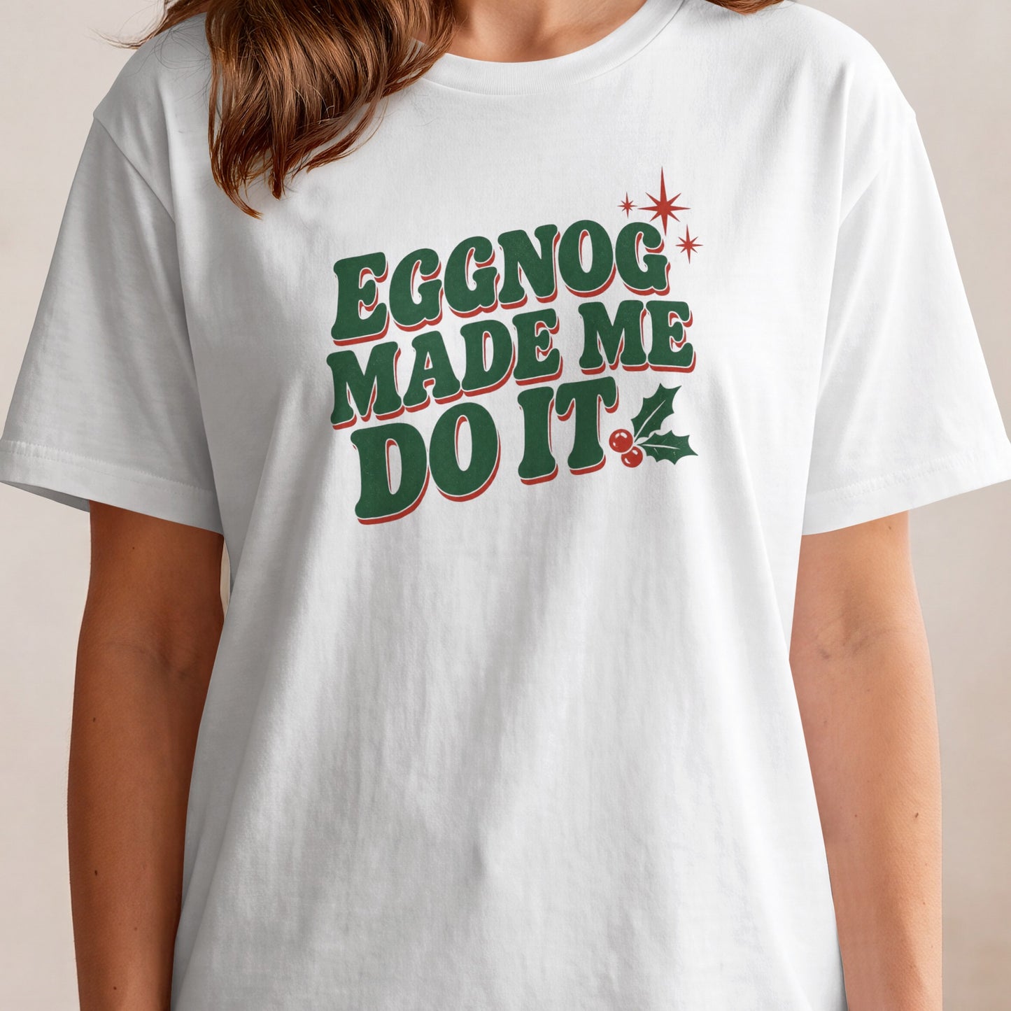 White t-shirt with green text "Eggnog Made Me Do It" and holly.