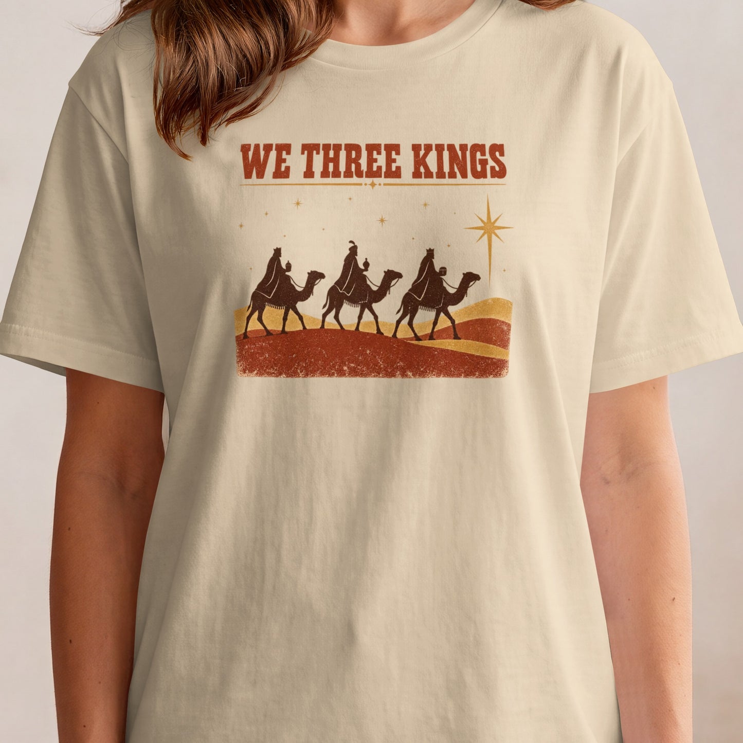 T-shirt with "WE THREE KINGS" and camels on a desert landscape.