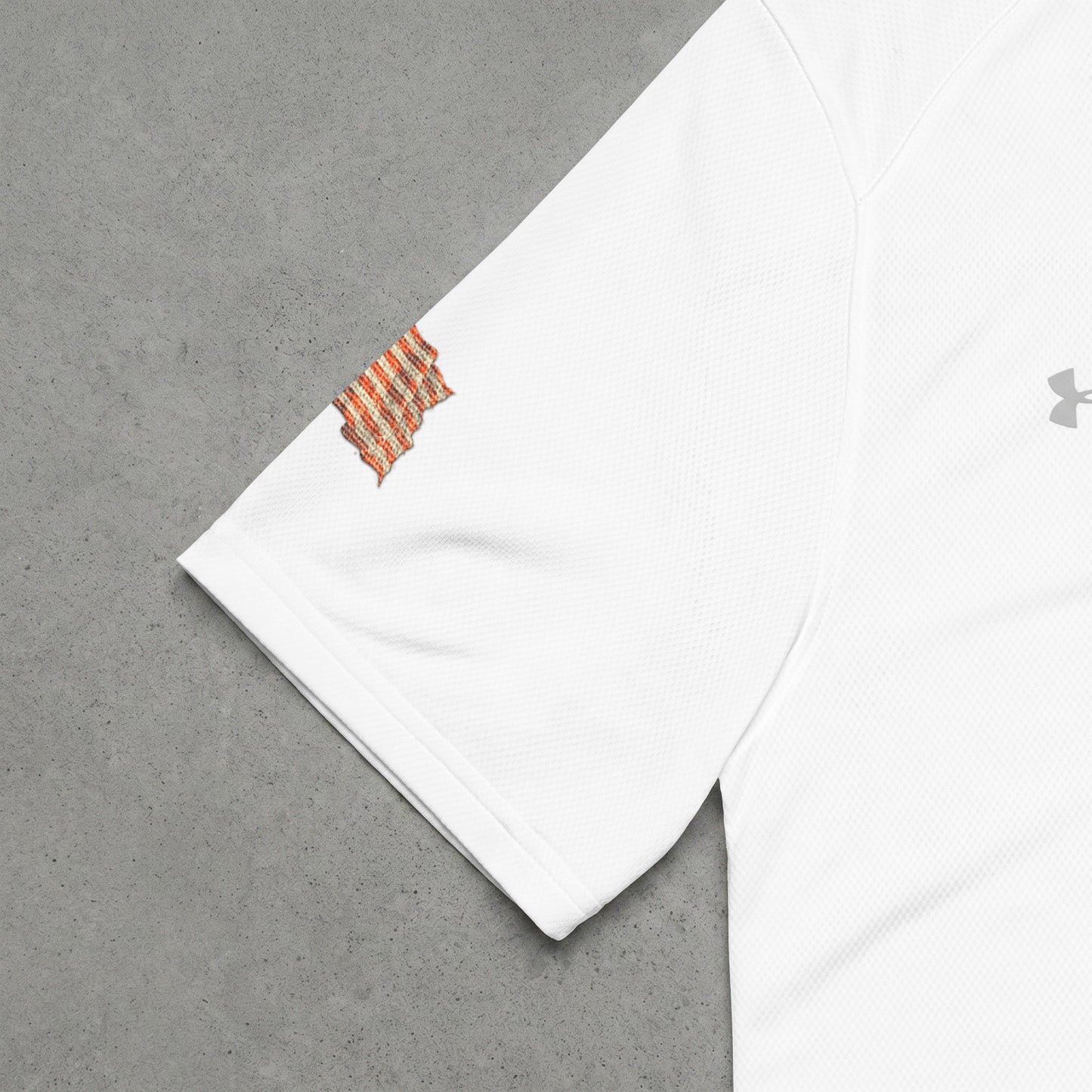 White Under Armour shirt sleeve with embroidered patch and gray logo.