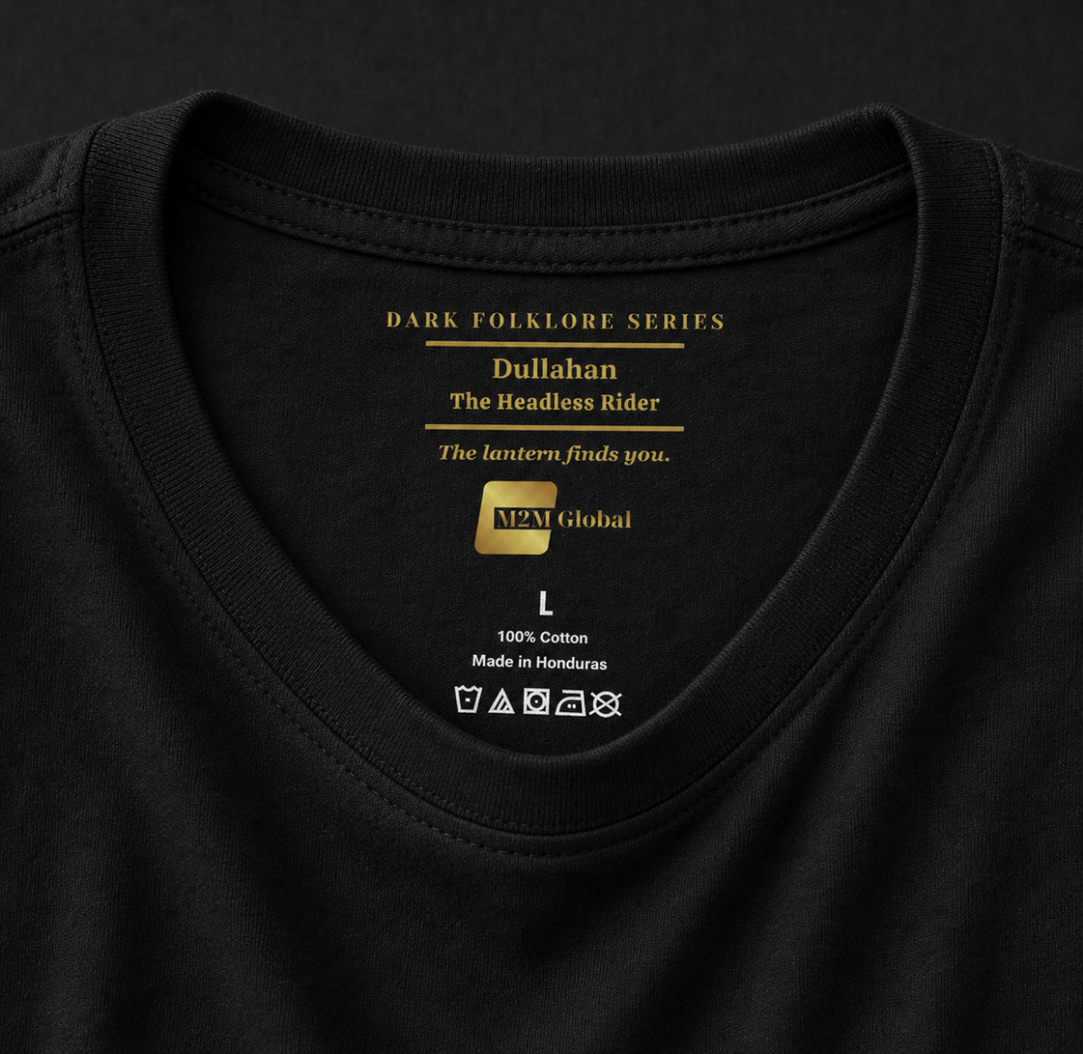 Inside neck of a black t-shirt showing the gold Dark Folklore Series label: Dullahan, The Headless Rider, with the original size and care label below.