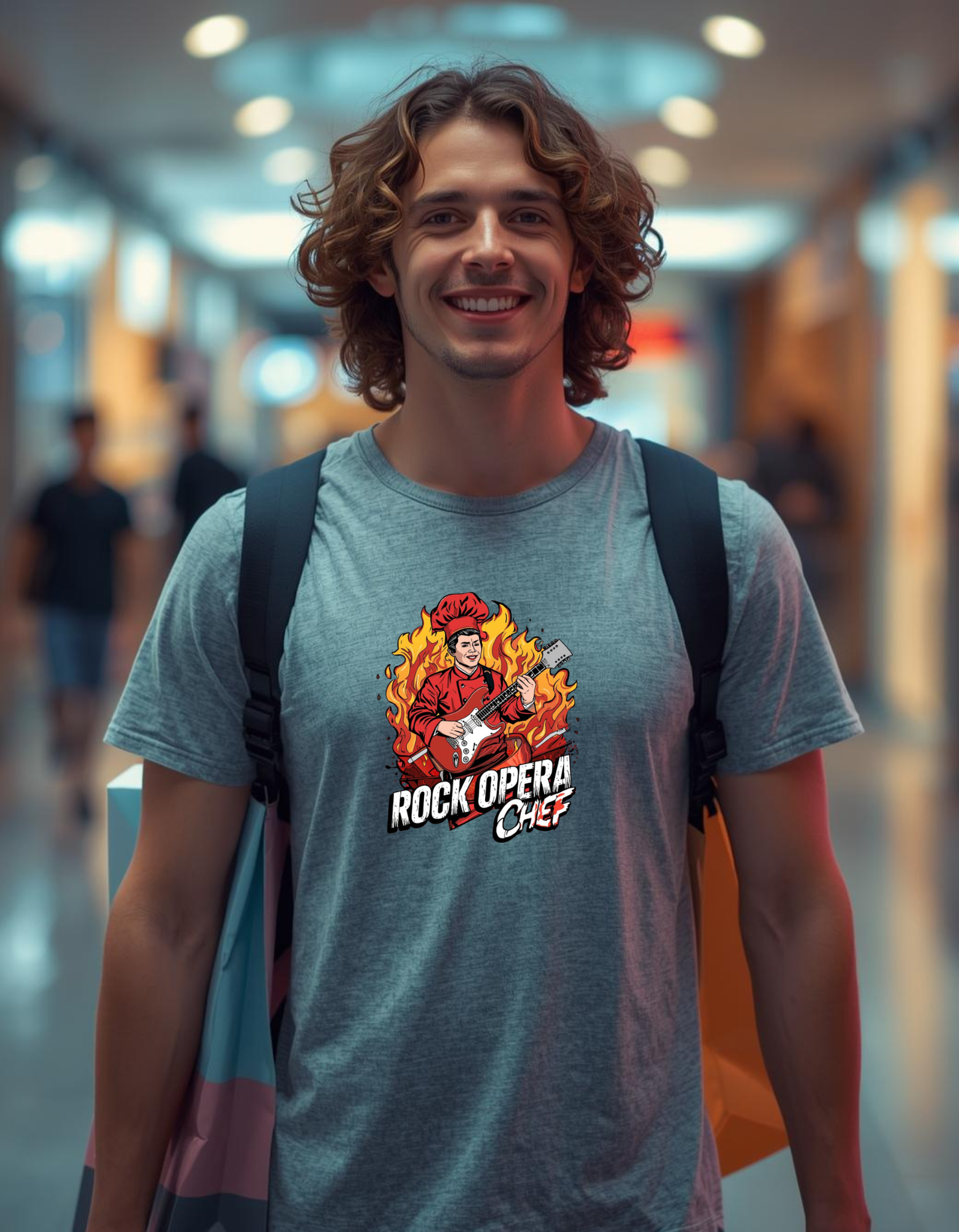 Man wearing a t-shirt with 'Rock Opera Chef' design in a blurred indoor setting