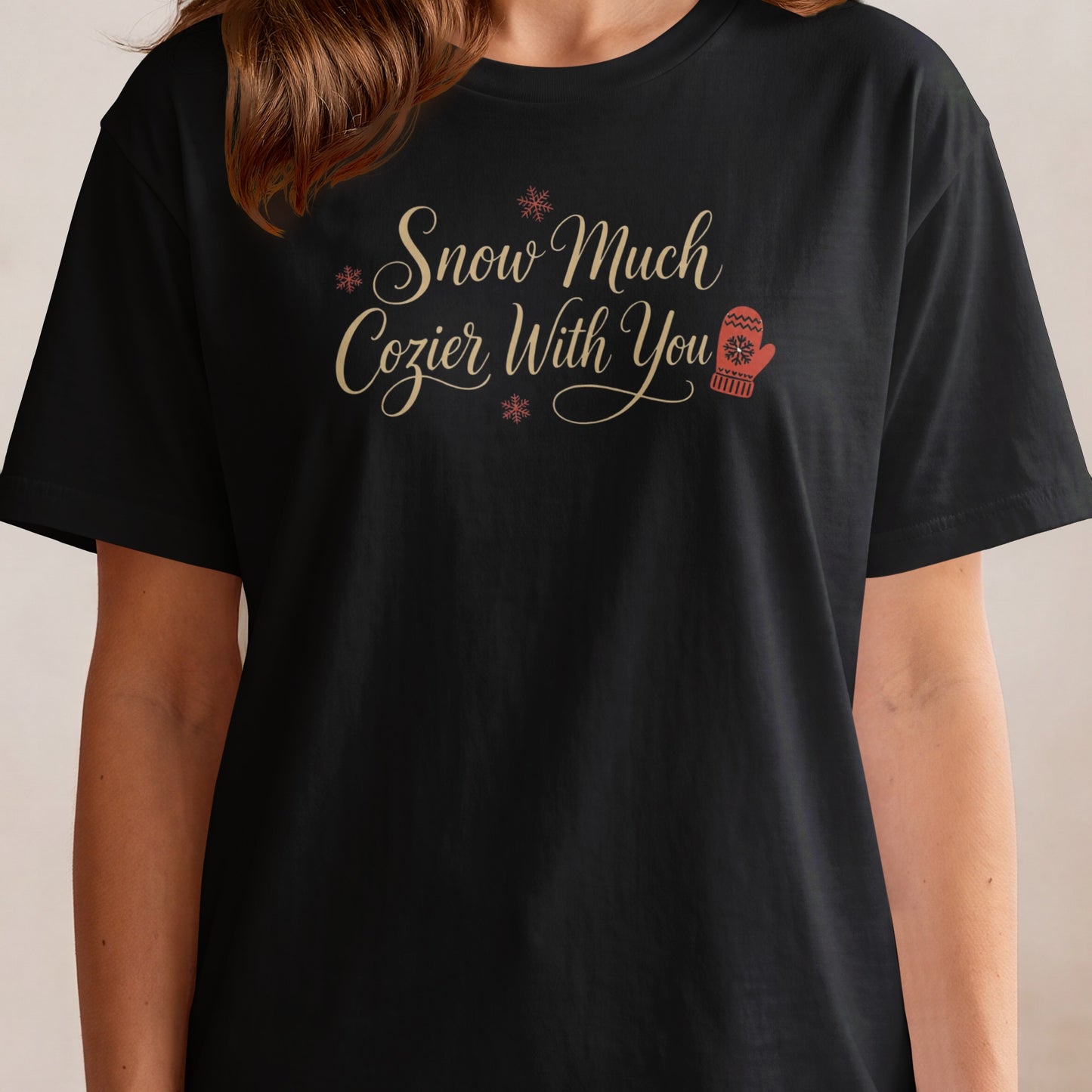 Black t-shirt with "Snow Much Cozier With You" text and snowflake and mitten graphics.