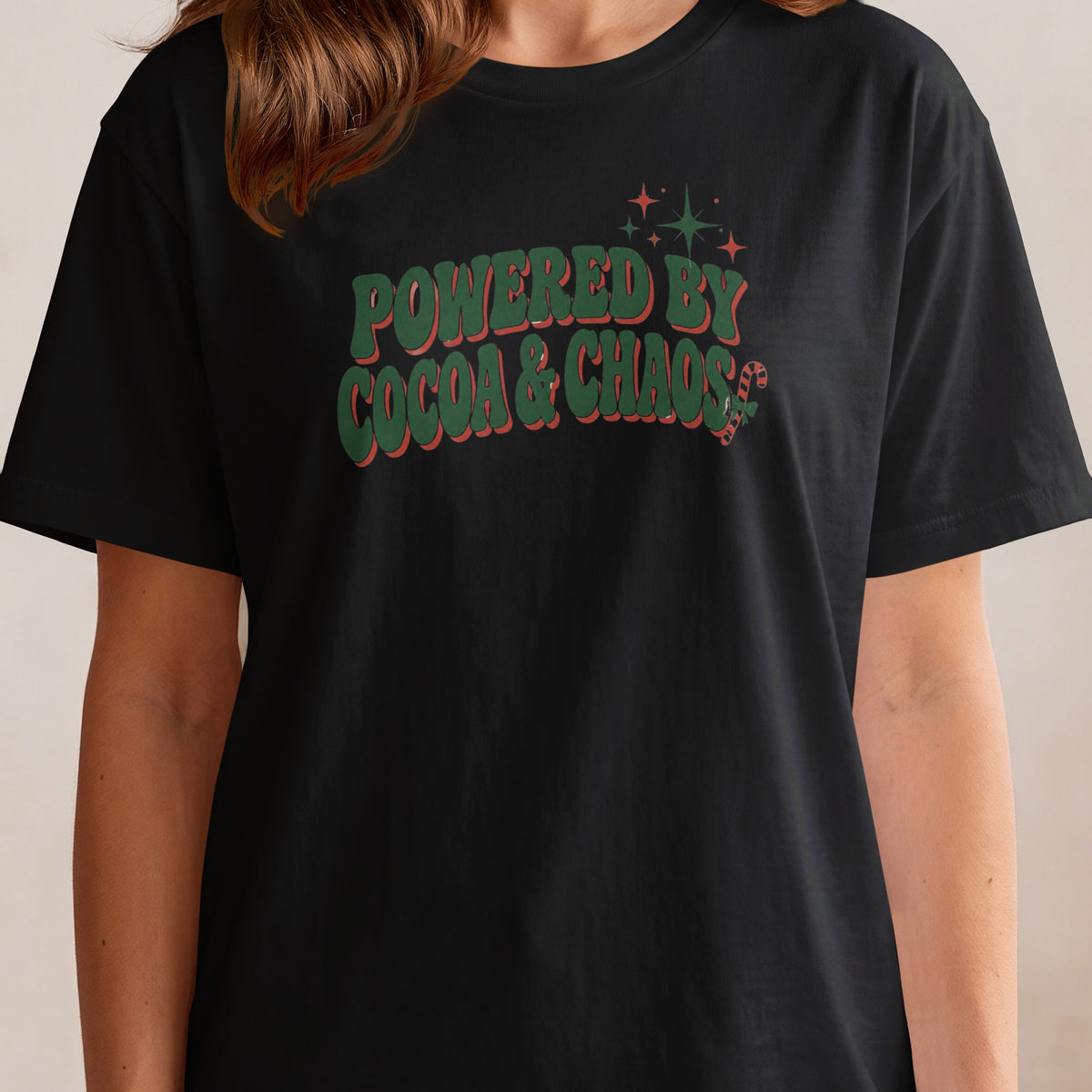 Black t-shirt with green and red text "POWERED BY COCOA & CHAOS".