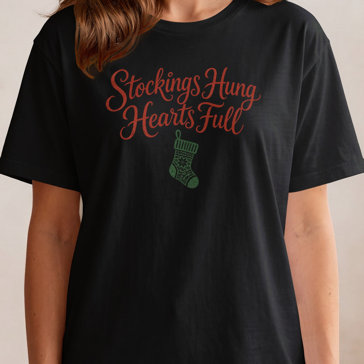 Black t-shirt with red "Stockings Hung Hearts Full" text and green stocking graphic.