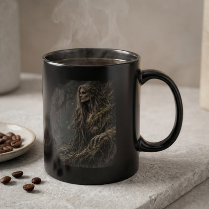 Black mug with steaming coffee features a dark forest scene with a tree-like mythical creature.