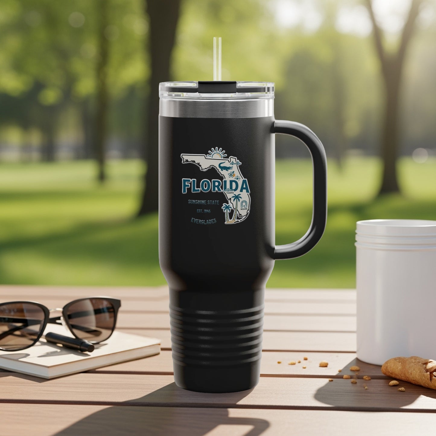 Black tumbler with Florida map graphic and "Sunshine State" text, outdoors.