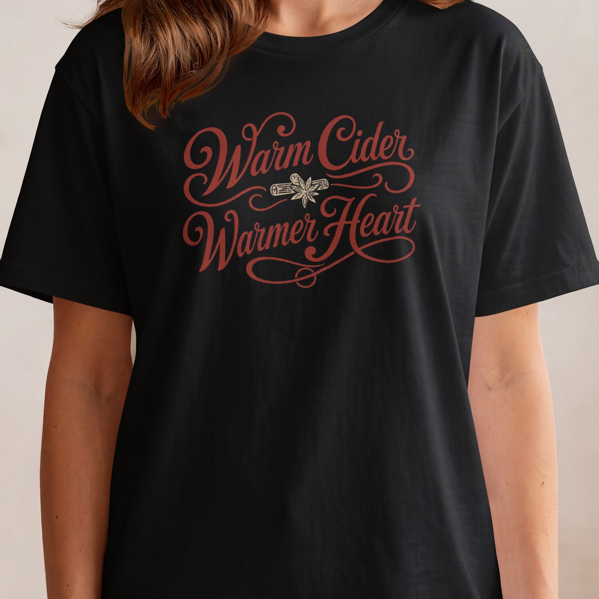 Black t-shirt with "Warm Cider Warmer Heart" in red script and spice illustration.