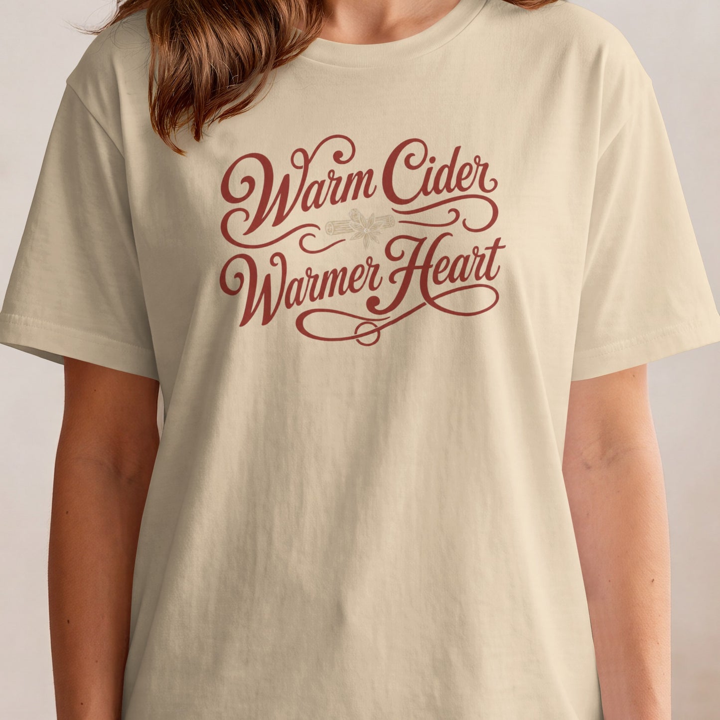 Cream t-shirt with "Warm Cider Warmer Heart" text and cinnamon stick illustration.
