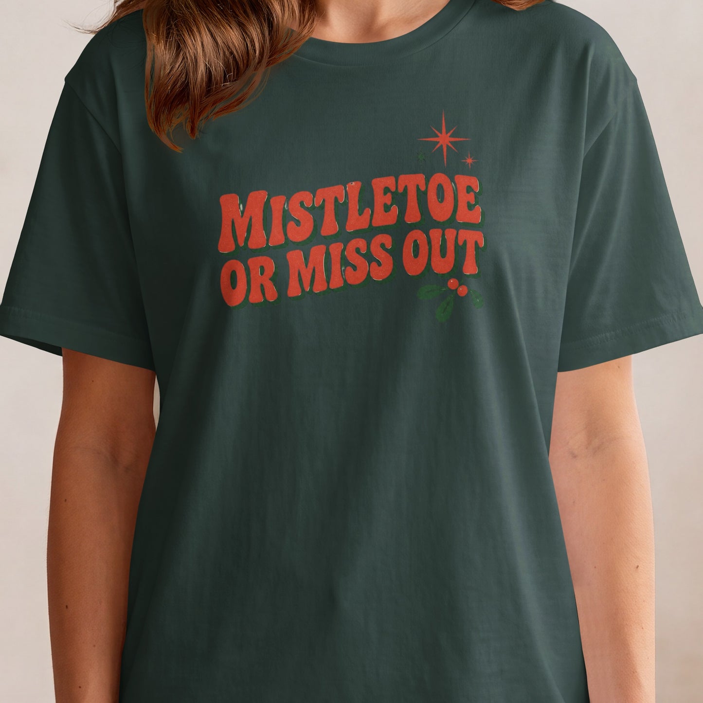 Dark green t-shirt with red text "MISTLETOE OR MISS OUT" and mistletoe design.