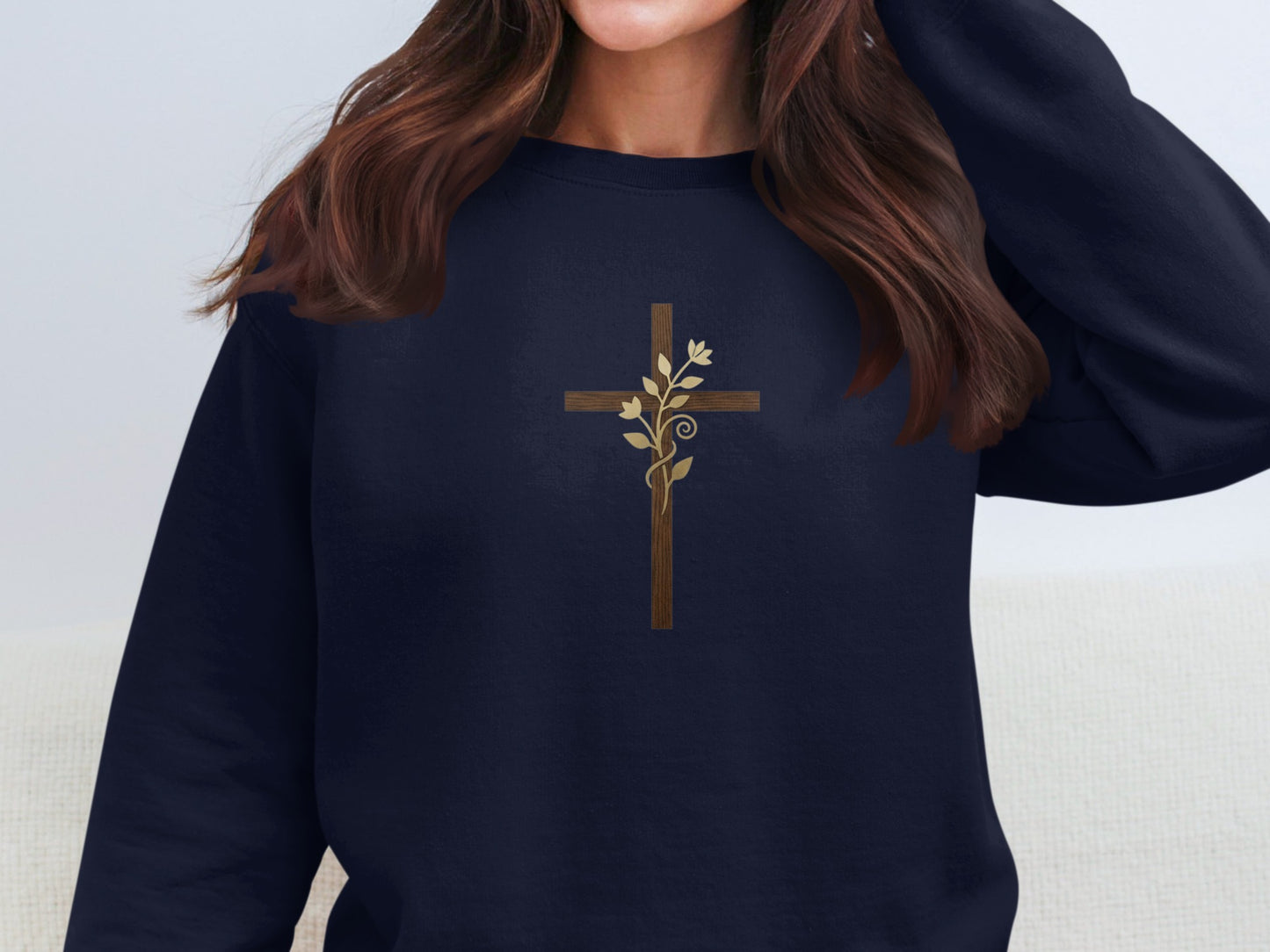 Navy sweatshirt with a brown wooden cross and gold floral vine design.
