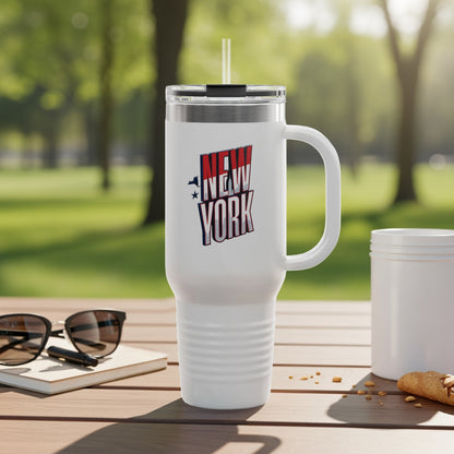 White travel mug with "New York" logo, sunglasses, and croissant on a table.