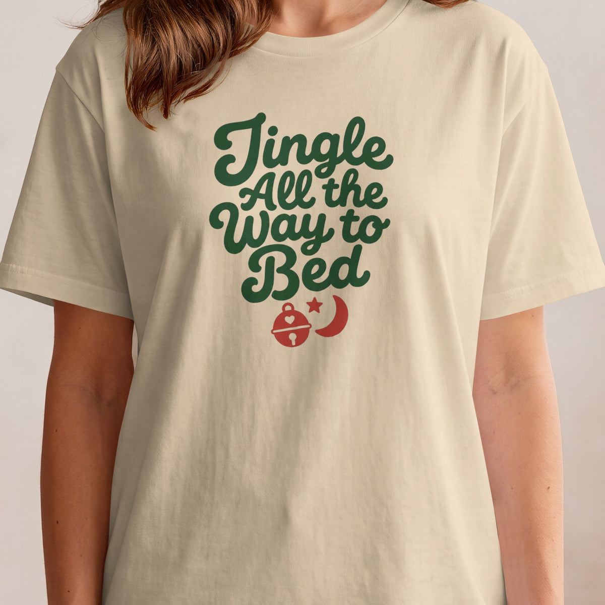 T-shirt with green text "Jingle All the Way to Bed" and red holiday graphics.