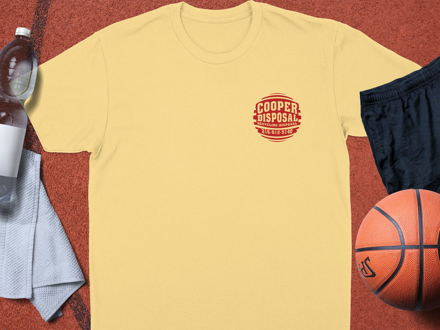 Yellow t-shirt with red "Cooper Disposal" logo, basketball, water bottle, and shorts.