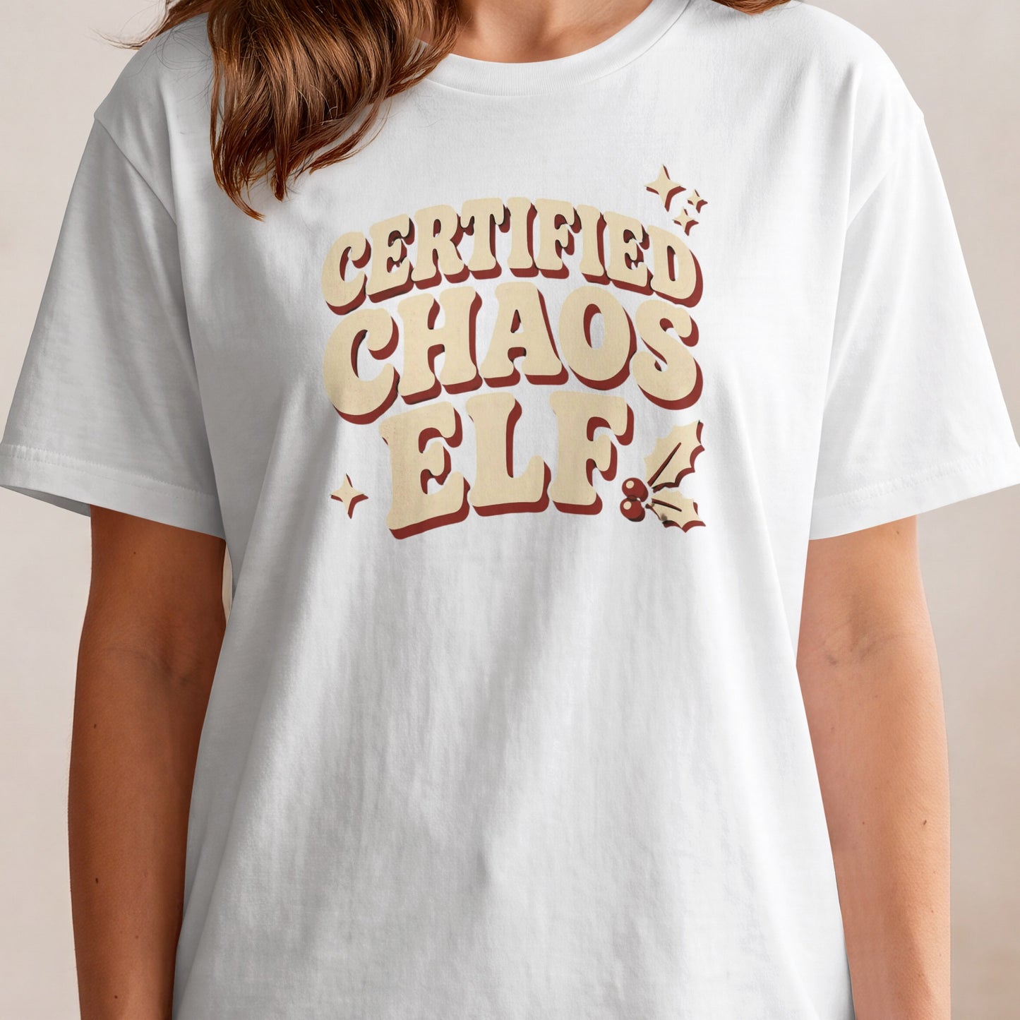 White t-shirt with "Certified Chaos Elf" text and holiday graphics.