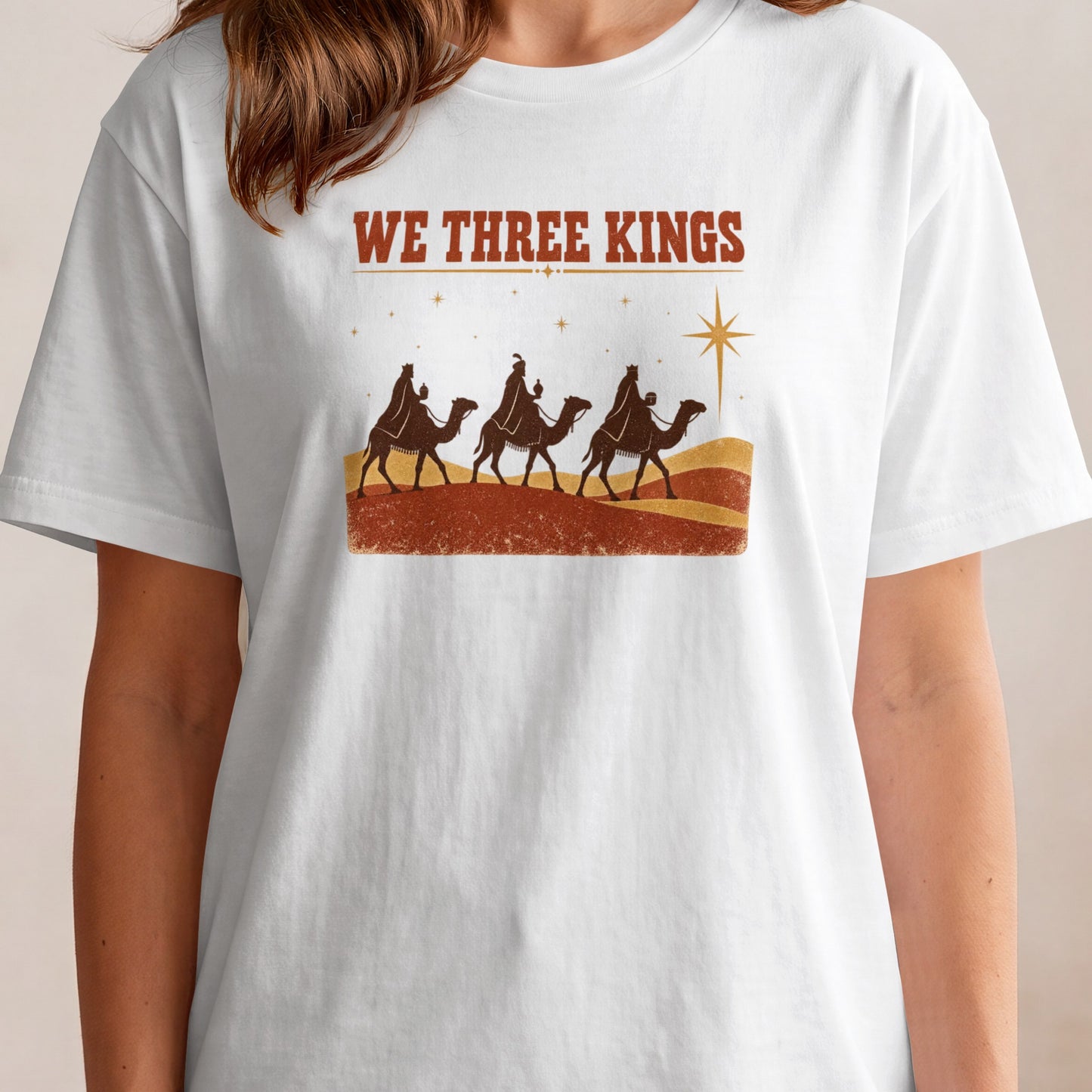 White t-shirt with "WE THREE KINGS" text and a vintage Christmas nativity scene.
