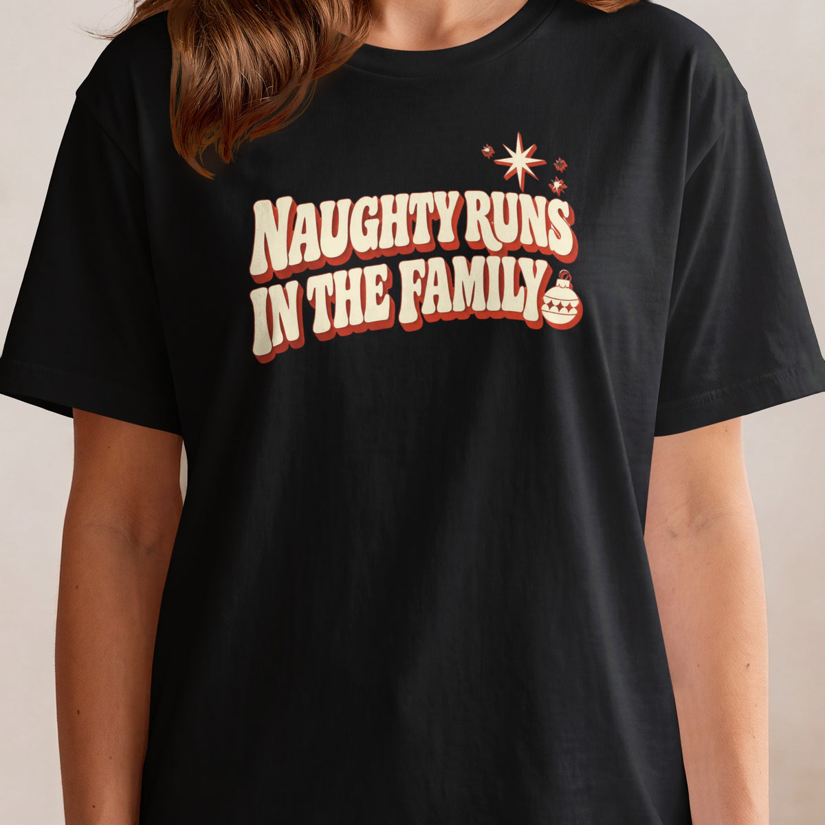 Black t-shirt with retro text that reads "Naughty Runs In The Family" and a Christmas ornament.