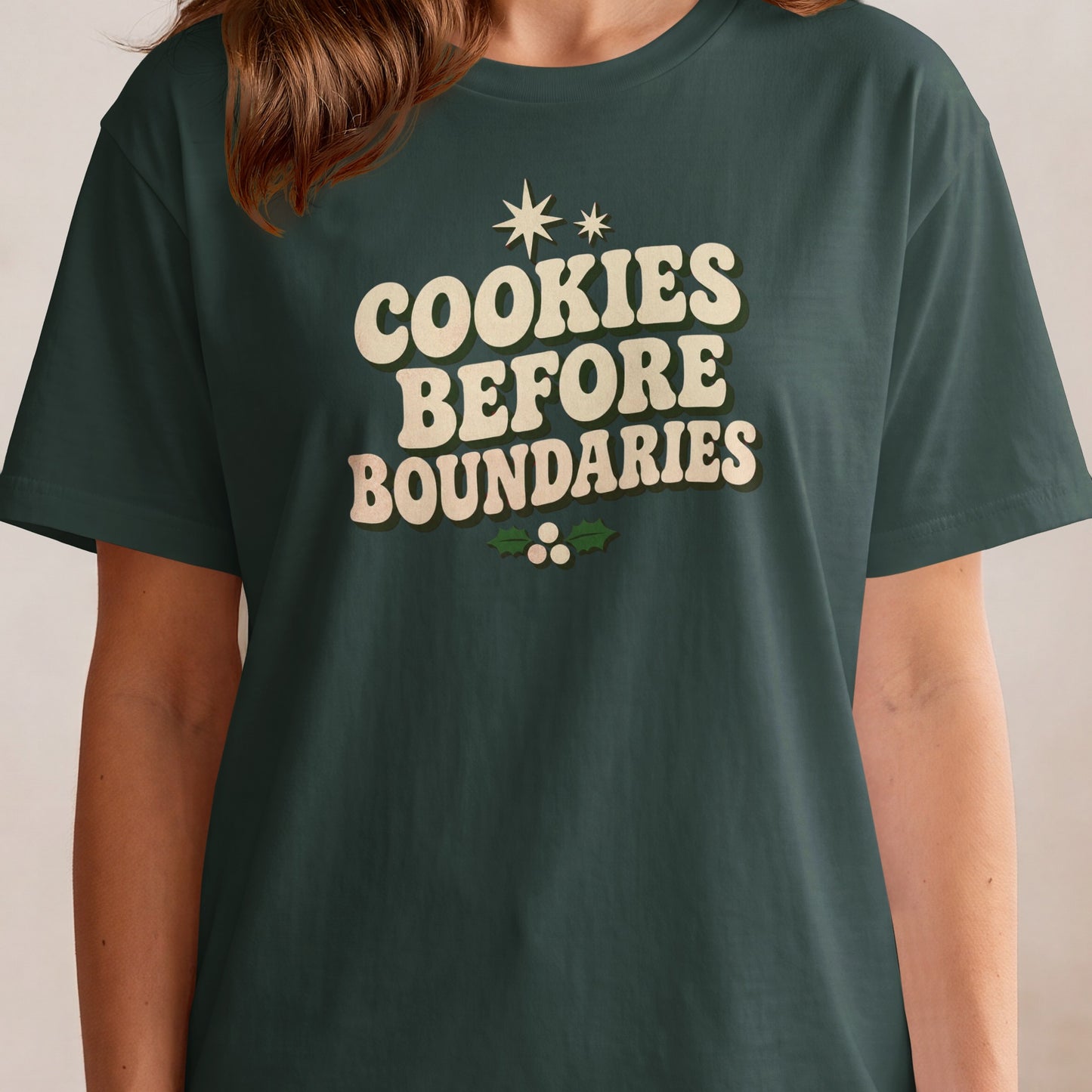 Dark green t-shirt with "Cookies Before Boundaries" text and holly.