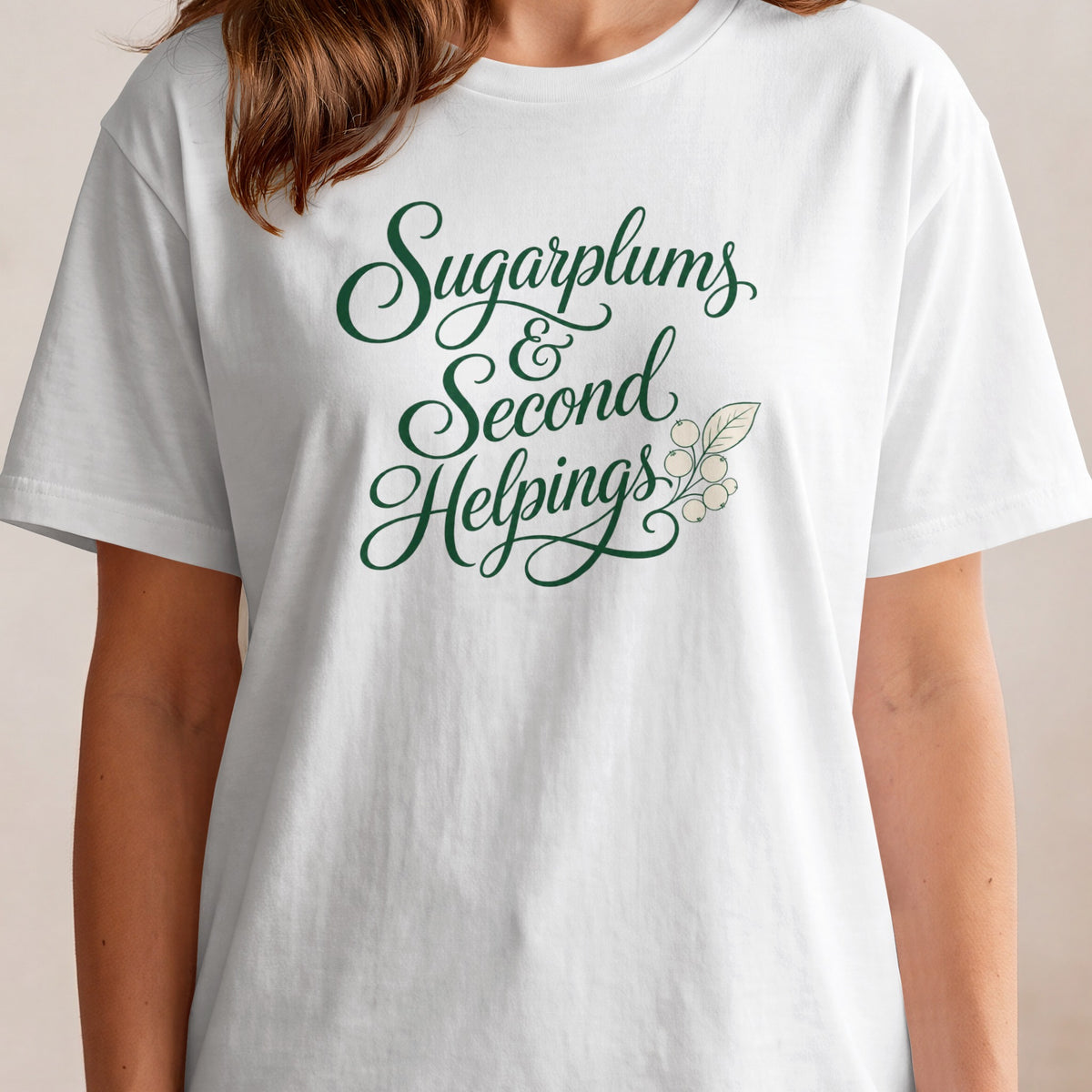 White t-shirt with green script text "Sugarplums & Second Helpings" and berry branch.