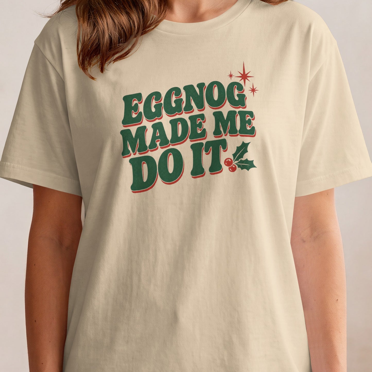 Eggnog Made Me Do It text on a beige t-shirt with holiday graphics.