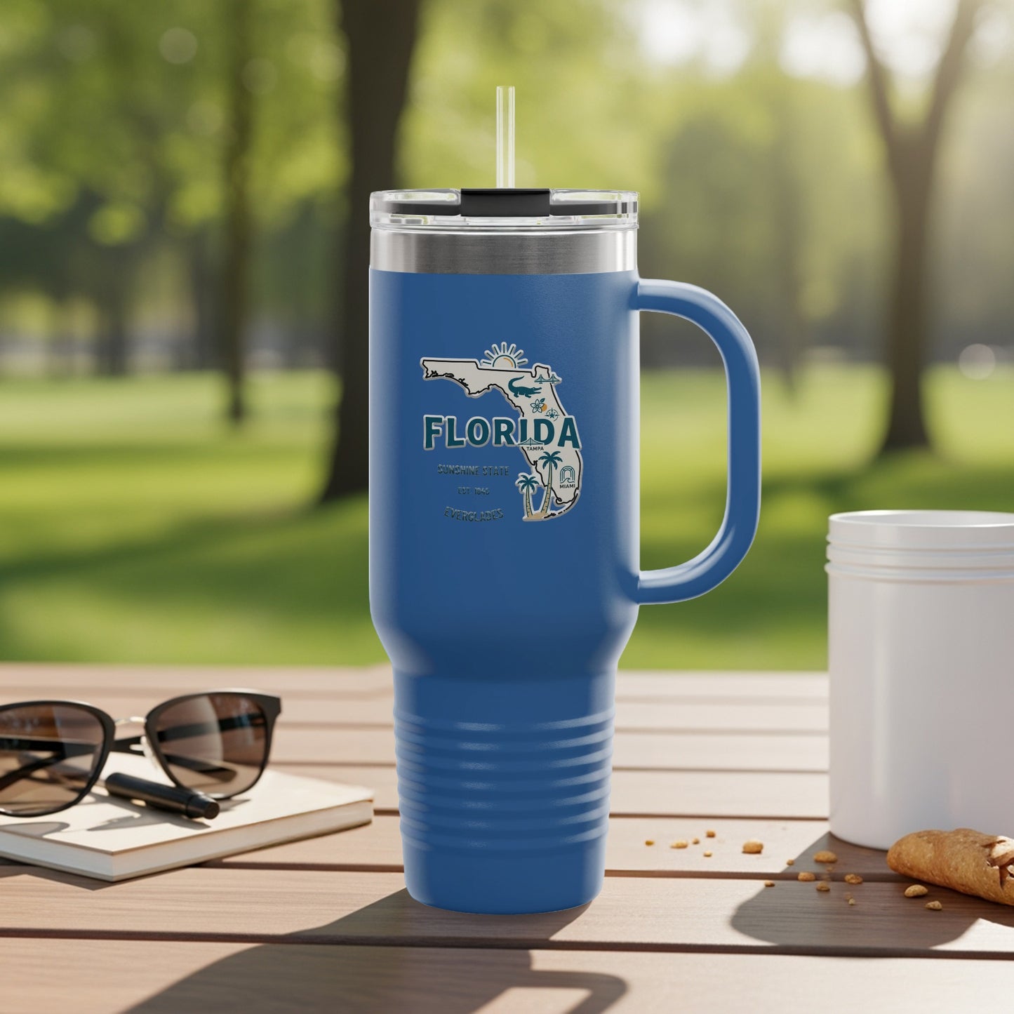Travel tumbler with Florida Sunshine State logo, outdoors.