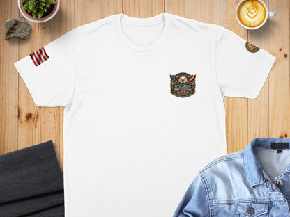 White t-shirt with US flag sleeve detail and patriotic emblem.