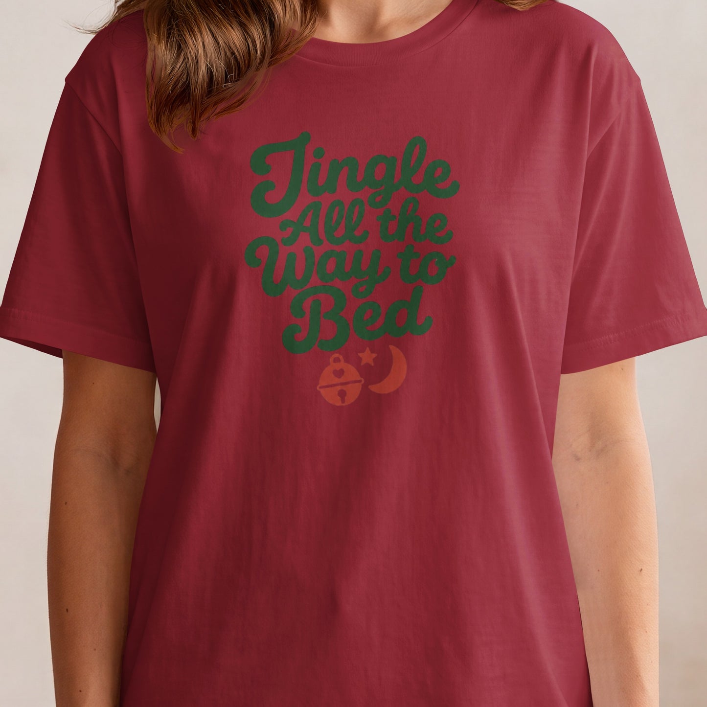 Maroon t-shirt with green text "Jingle All the Way to Bed" and bell graphic.