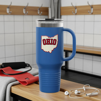 Blue tumbler with Ohio outline logo, on wooden bench with gym equipment.