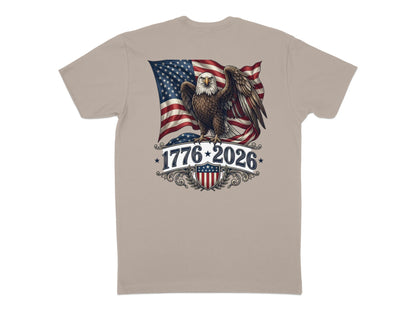 Eagle with American flag, “1776-2026” text, and shield graphic on a tan t-shirt.