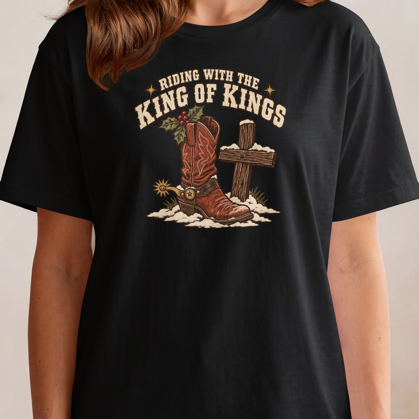 Black t-shirt graphic with cowboy boot, cross, and text: "Riding with the King of Kings".