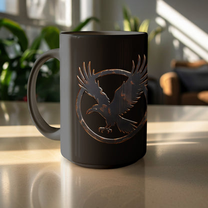 Black mug with a distressed raven emblem inside a circular frame.