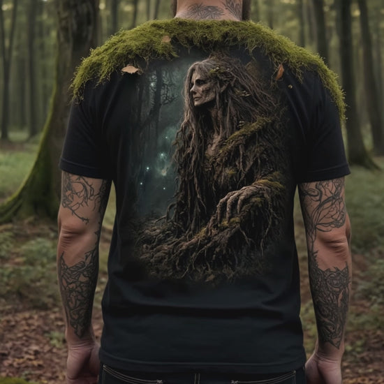 Man in the woods wearing a black t-shirt with a Forest Witch on the back.
